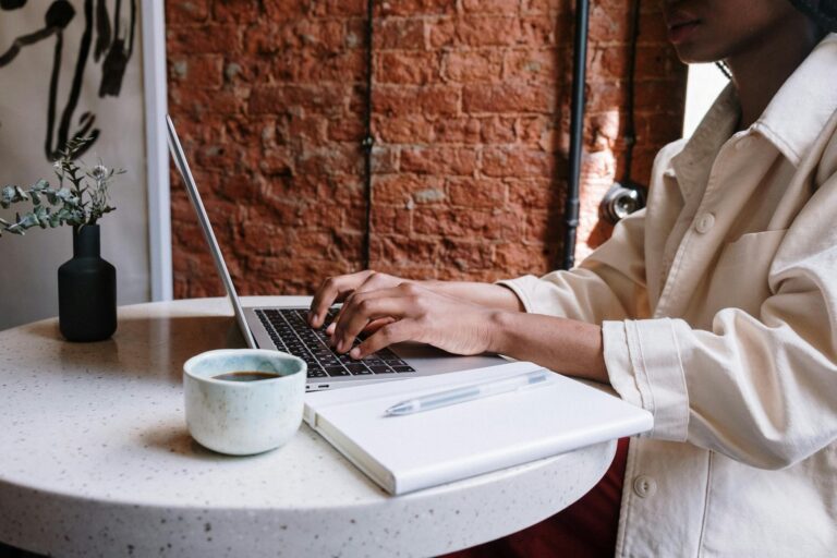 person in white long sleeve shirt using macbook pro